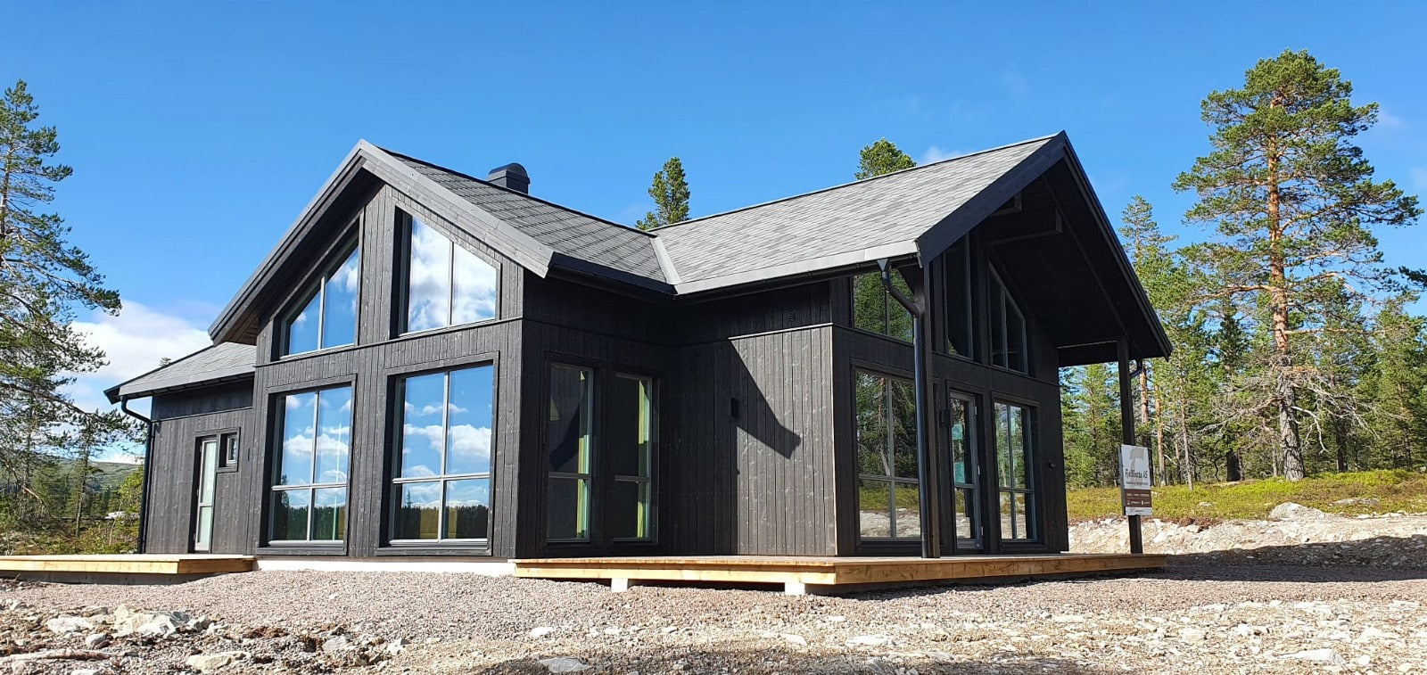 Moderna privātmāja ar lieliem logiem un dedzināta koka imitācijas ārējo fasādi