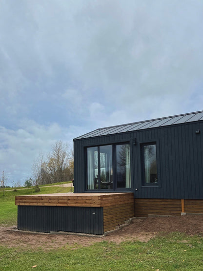 Moderna koka karkasa moduļu māja ar terasi un vitrīnas logiem, sānskats